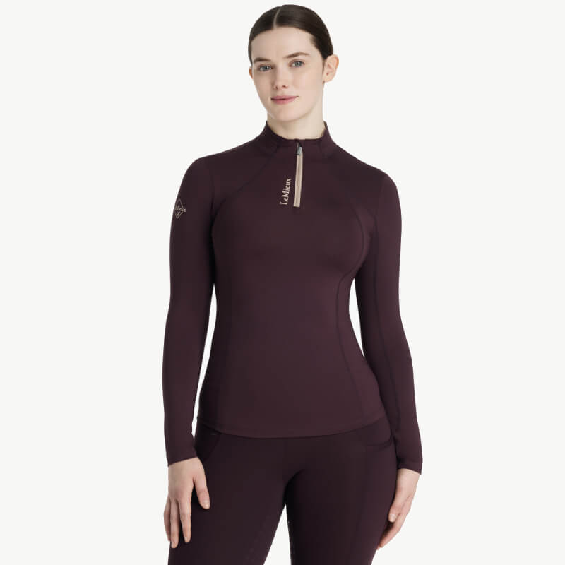 Woman in LeMieux Classique Baselayer Damson, standing and smiling.