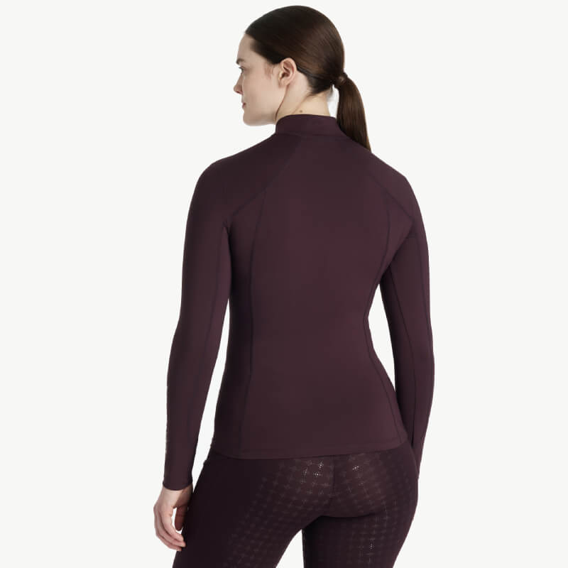 Woman wearing a LeMieux Classique Baselayer Damson, facing away.