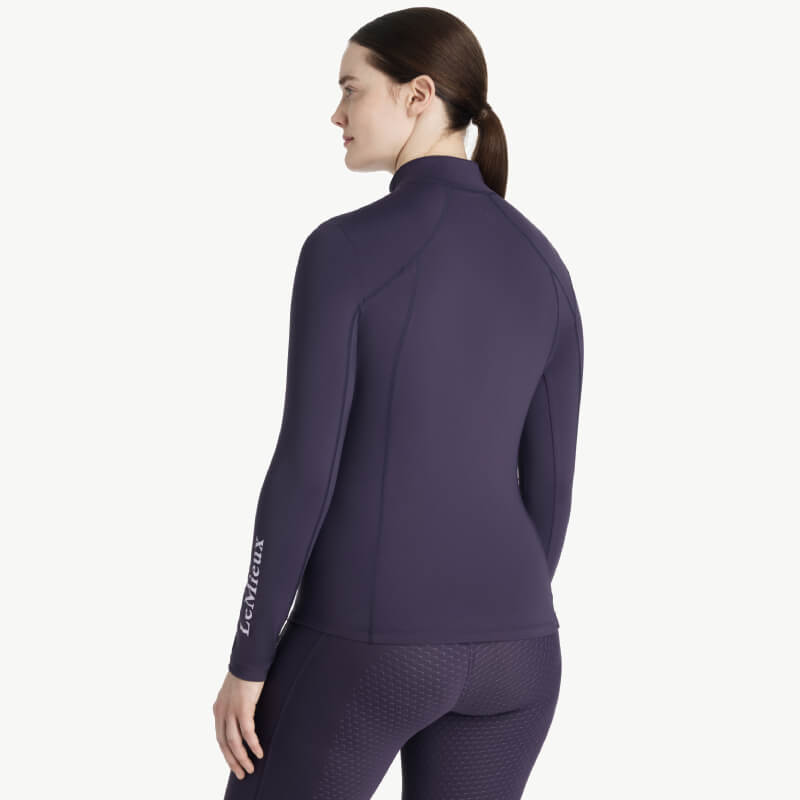 Woman in LeMieux Classique Baselayer Juniper, facing away.