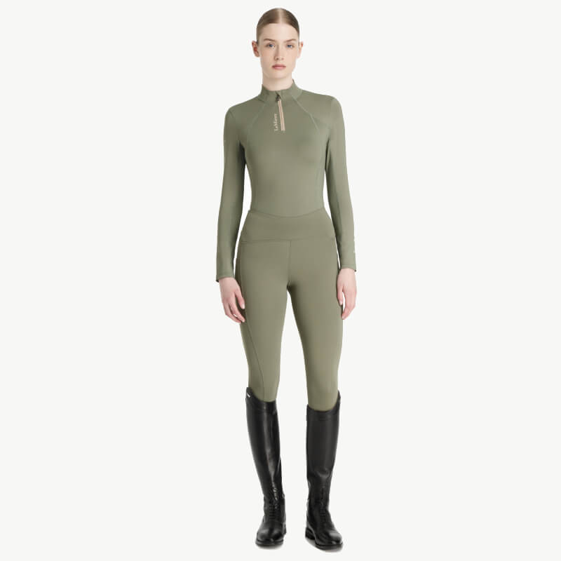 Woman in the LeMieux Classique Baselayer Rosemary, styled with black boots.