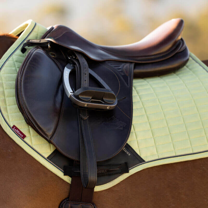 LeMieux Suede Close Contact Square Macaron saddle pad in light green with black trim and patches.