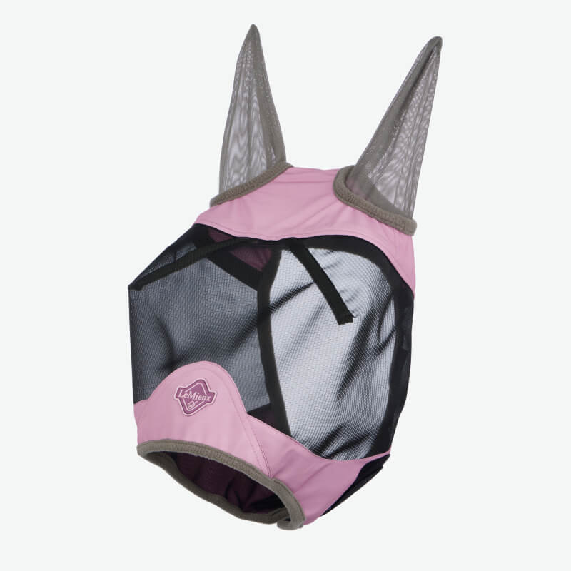 A brown horse wears a pink LeMieux Visor-Tek Half Fly Mask Fondant for UV protection outdoors.