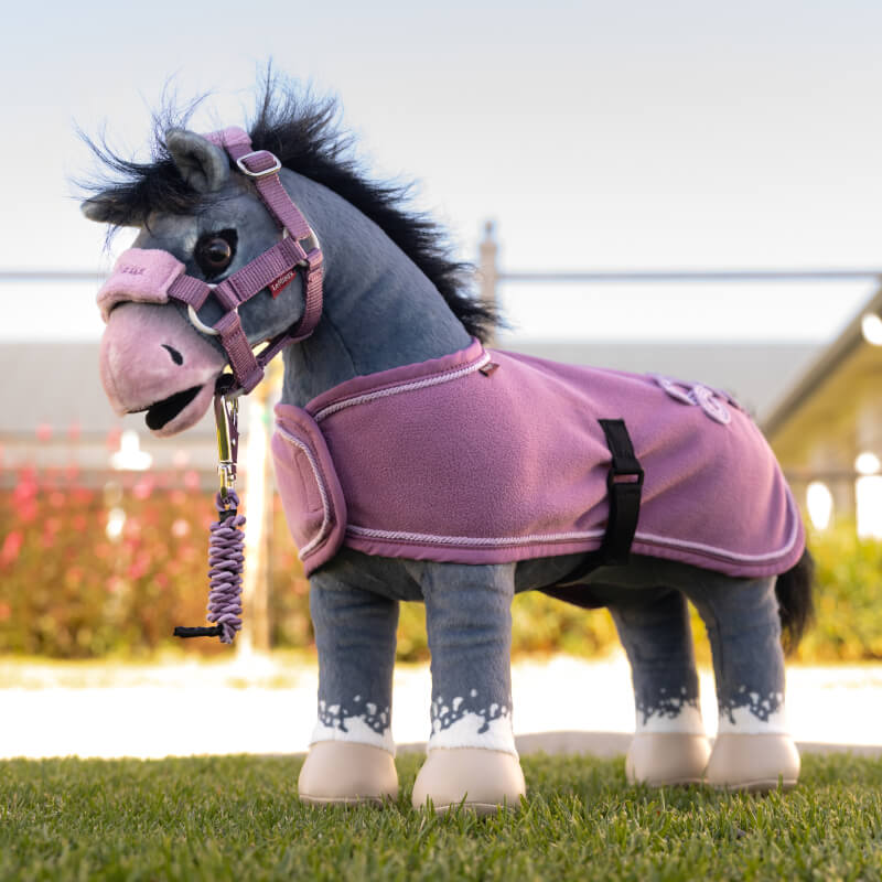Pink LeMieux Toy Pony Rug Mallow with white trim, black strap, and braided tail accent.