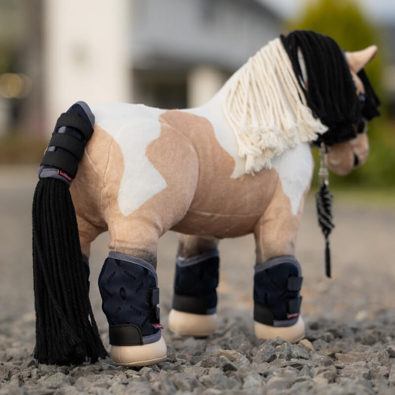 Four navy pads & a wrist guard from the LeMieux Toy Pony Travel Set Navy, perfect for play.