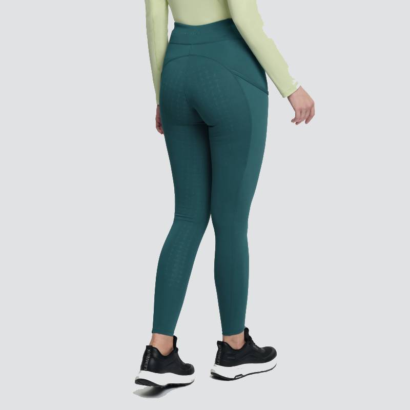 Person in LeMieux Naomi Pull On Breech Jungle, light green top, black sneakers; back view.