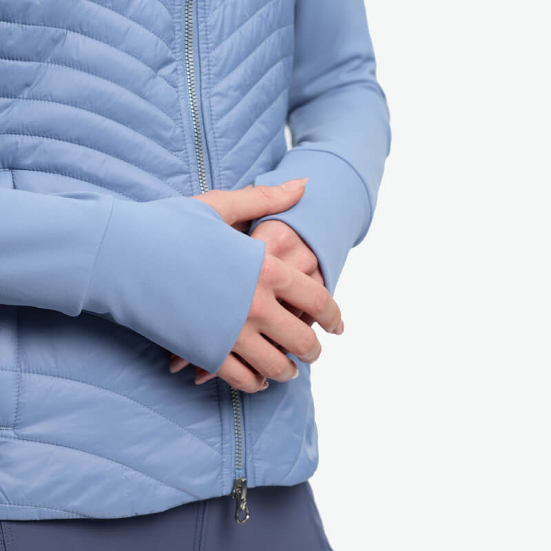 Person wears LeMieux Juliette Jacket Powder Blue with thumb holes and lightweight insulation.