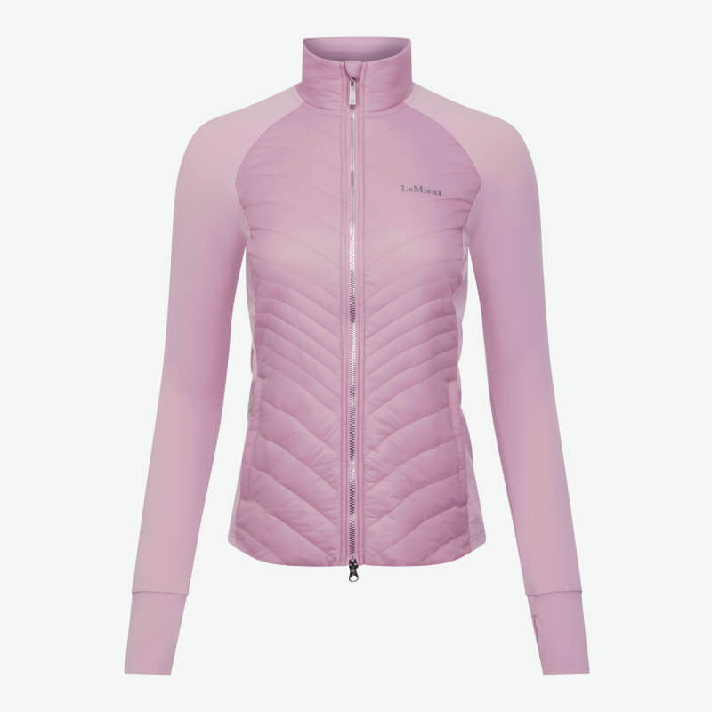 Woman in LeMieux Juliette Jacket Fondant stands by a brown horse in pink gear.