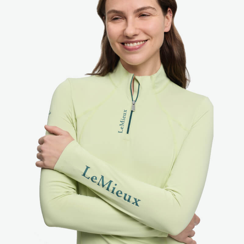 Smiling woman in a LeMieux Classique Baselayer Macaron with arms folded.