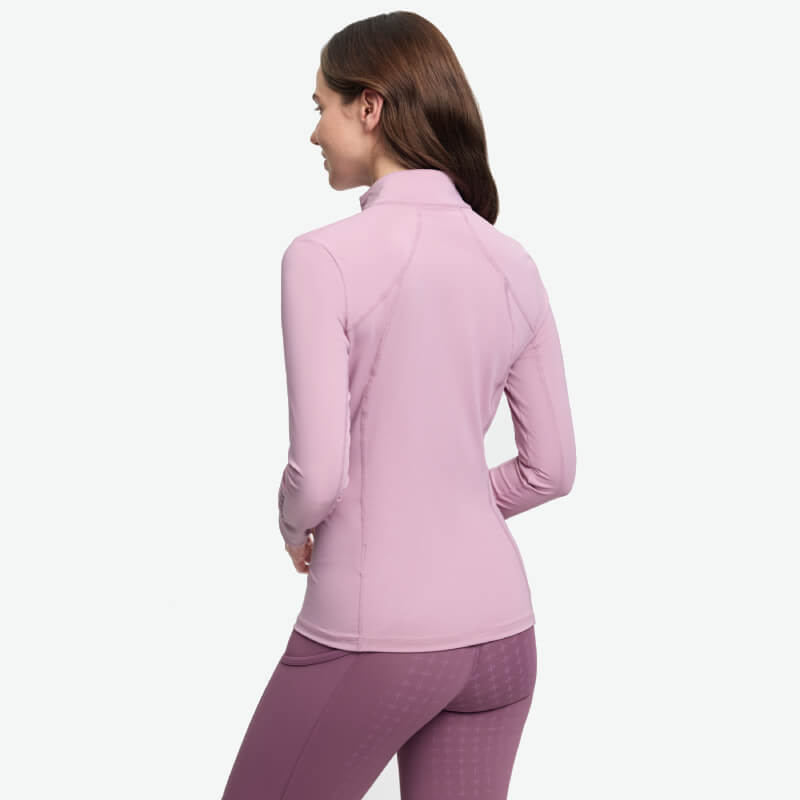 Woman in LeMieux Classique Baselayer Fondant, light purple, facing away.
