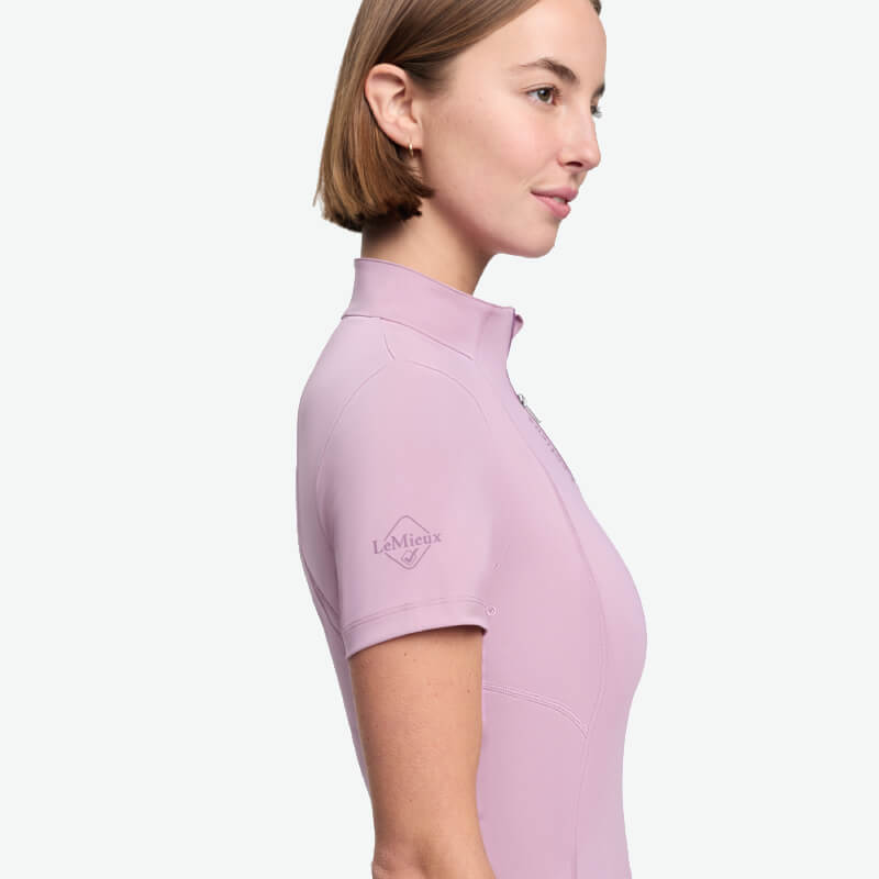 Woman in LeMieux Classique Short Sleeve Baselayer Fondant, side view, logo on sleeve.