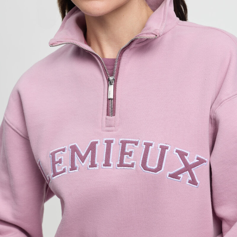 Wearing a LeMieux Kelsie Quarter Neck Sweat Fondant with bold logo and quarter-zip neckline.