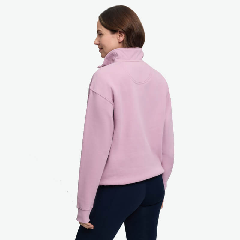 Woman in LeMieux Kelsie Quarter Neck Sweat Fondant, black pants, standing facing away.