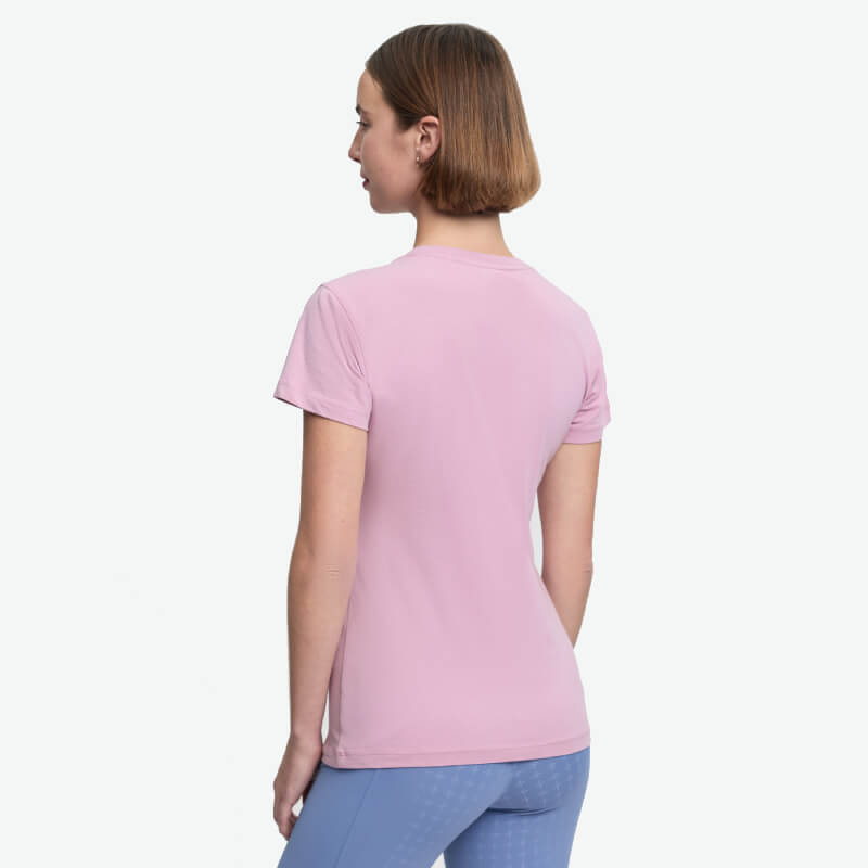 Woman in a LeMieux Classique T-Shirt Fondant and blue pants stands with her back to the camera.