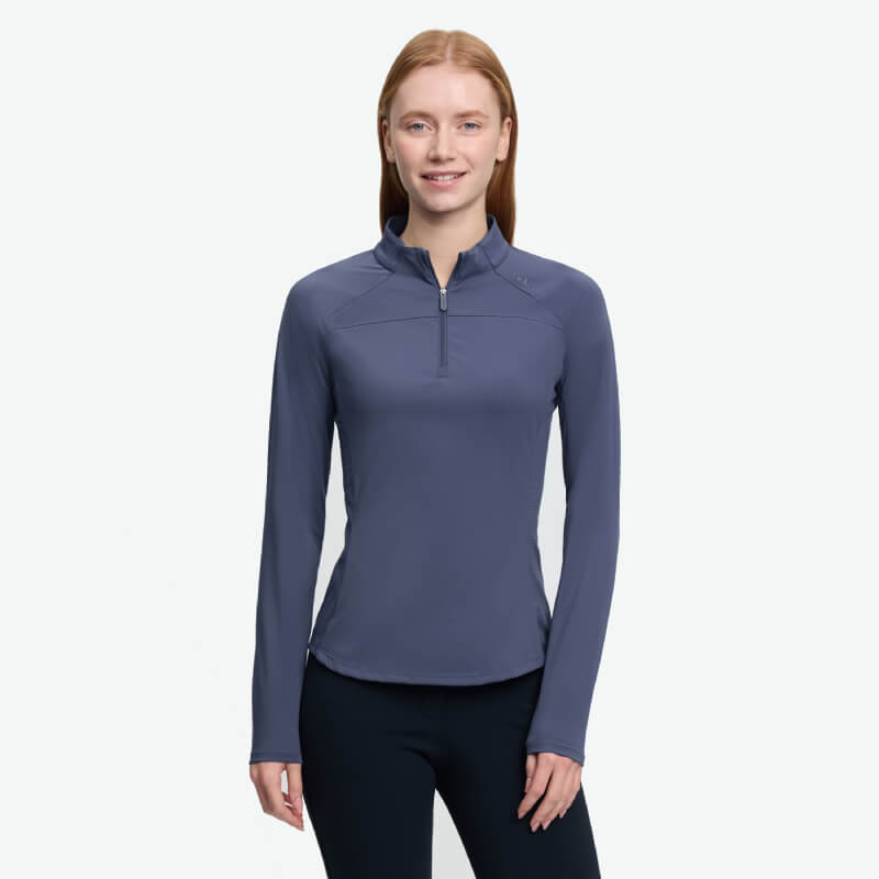 Woman in a LeMieux Airflow Long Sleeve Baselayer Shadow, smiling against a white background.