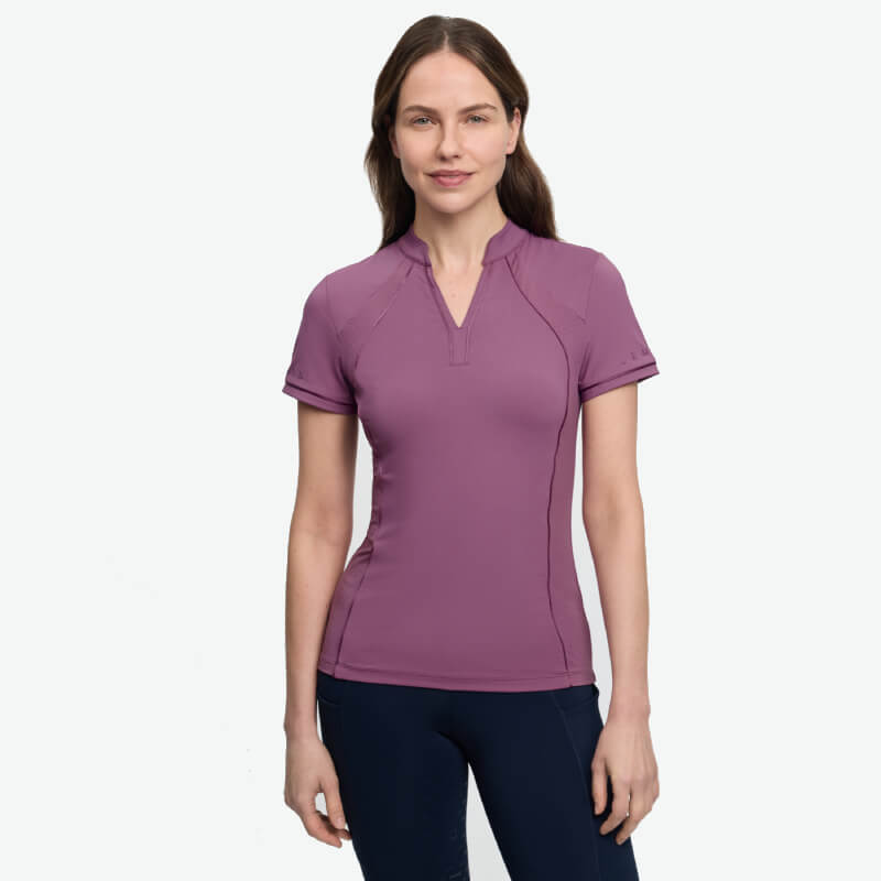 Woman in a LeMieux Lisa Mesh Baselayer Mallow and navy pants stands against a white background.