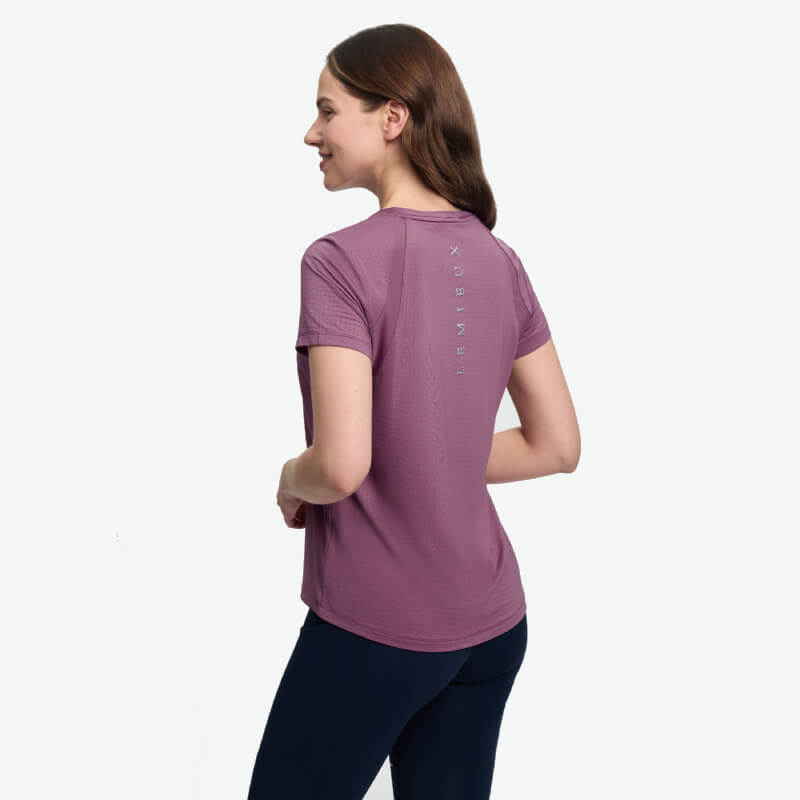 Woman in LeMieux Sports T-Shirt Mallow and dark pants, standing turned slightly to the side.