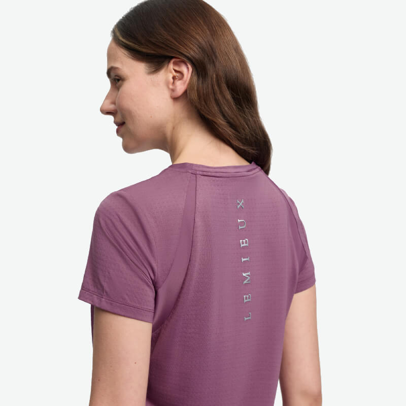 Woman in a LeMieux Sports T-Shirt Mallow, LEMIEUX text on back, facing away.