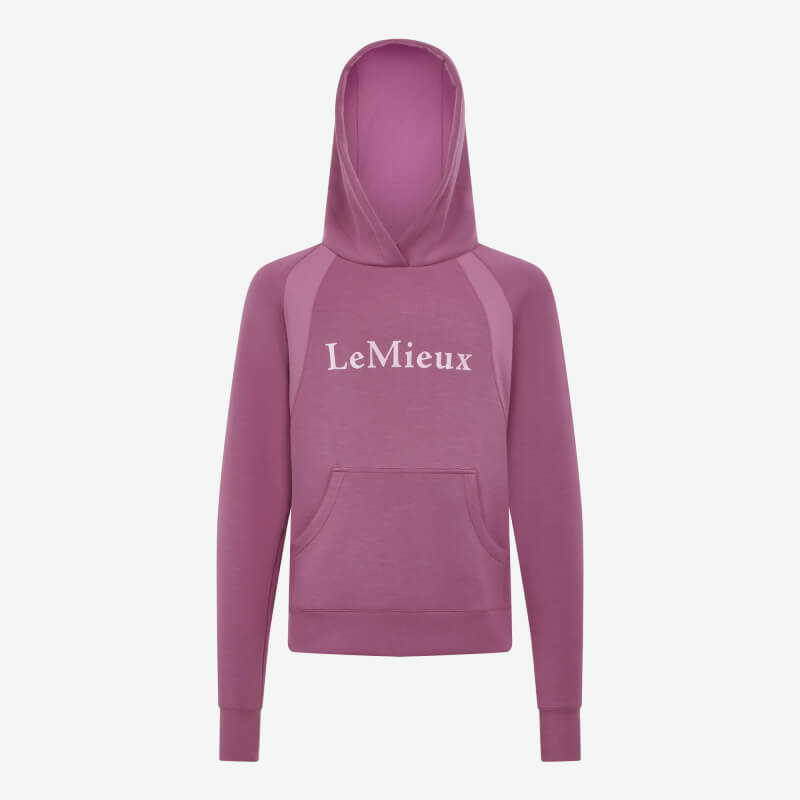 Smiling girl in LeMieux Young Rider Nancy Hoodie Mallow, hands in hoodie pocket.