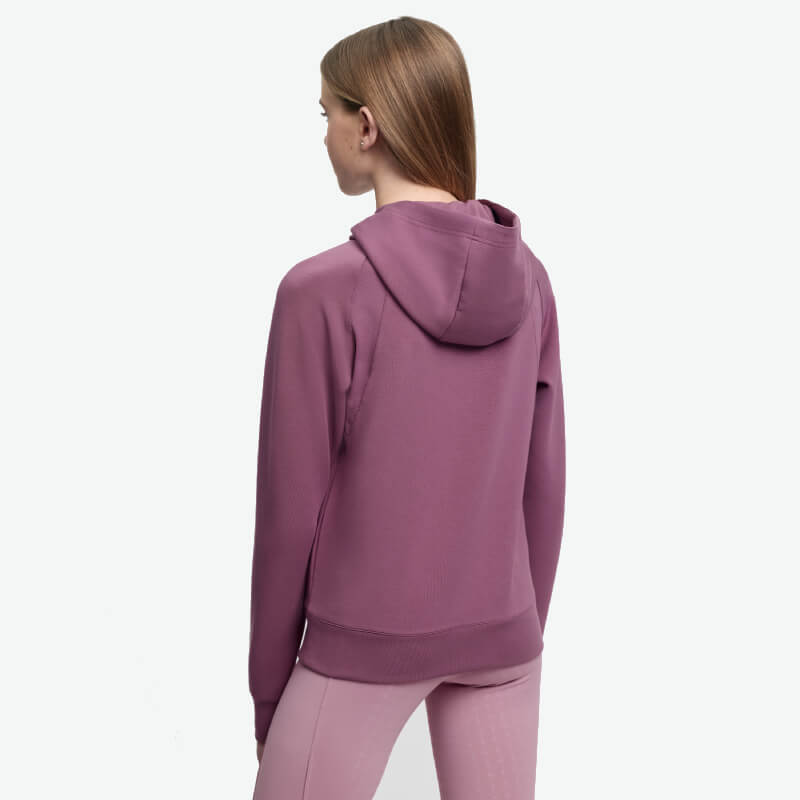 Person in LeMieux Young Rider Nancy Hoodie Mallow, pink leggings, faces away on white background.