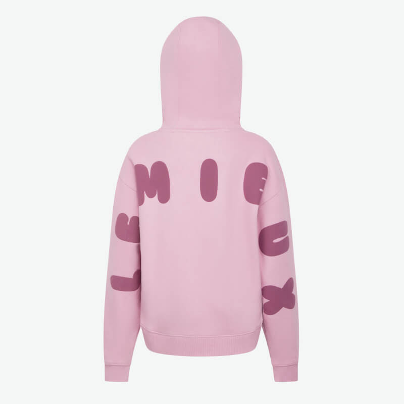 Teen girl smiles in LeMieux Young Rider Sia Hoodie Fondant, wearing dark pants, on white background.
