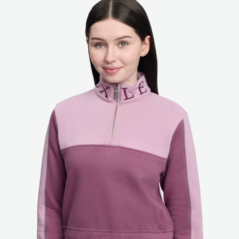 Smiling woman with long dark hair in LeMieux Young Rider Cropped Kate Quarter Zip Mallow top.