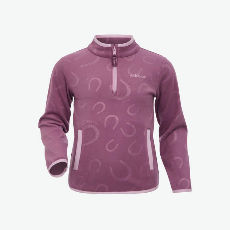 Smiling young girl in LeMieux Mini Maggie Fleece Mallow and matching leggings, against white.