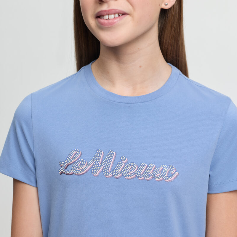 Girl wears LeMieux Young Rider Arianna T-Shirt Powder Blue with patterned front letters.