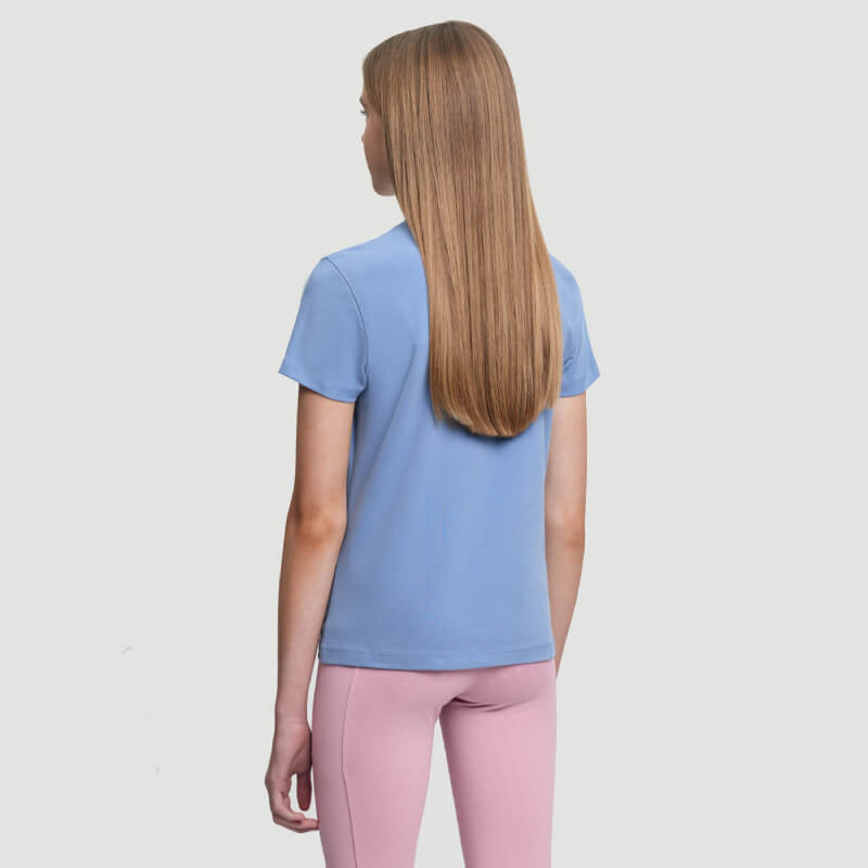 Long straight-haired person wears LeMieux Arianna T-Shirt Powder Blue, pink pants, facing away.
