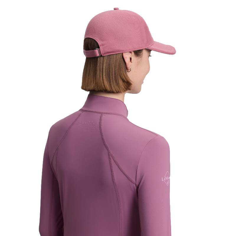 Person in a LeMieux Lara Cap Mallow and pink top, facing away against a white background.