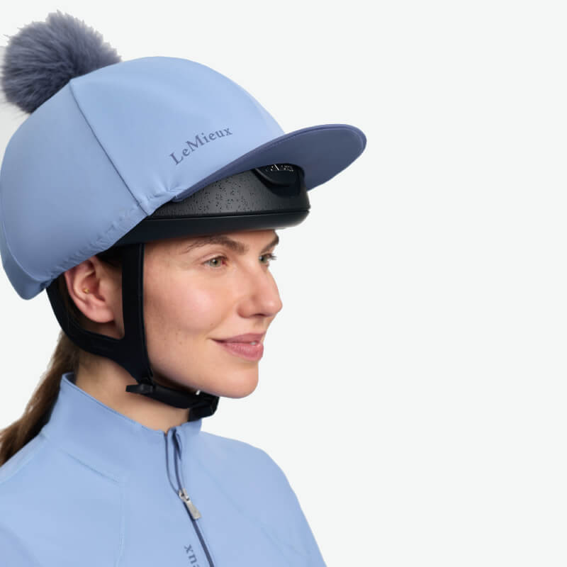 LeMieux Classique Pom Hat Silk in Powder Blue with fluffy pom and chin strap for helmets.