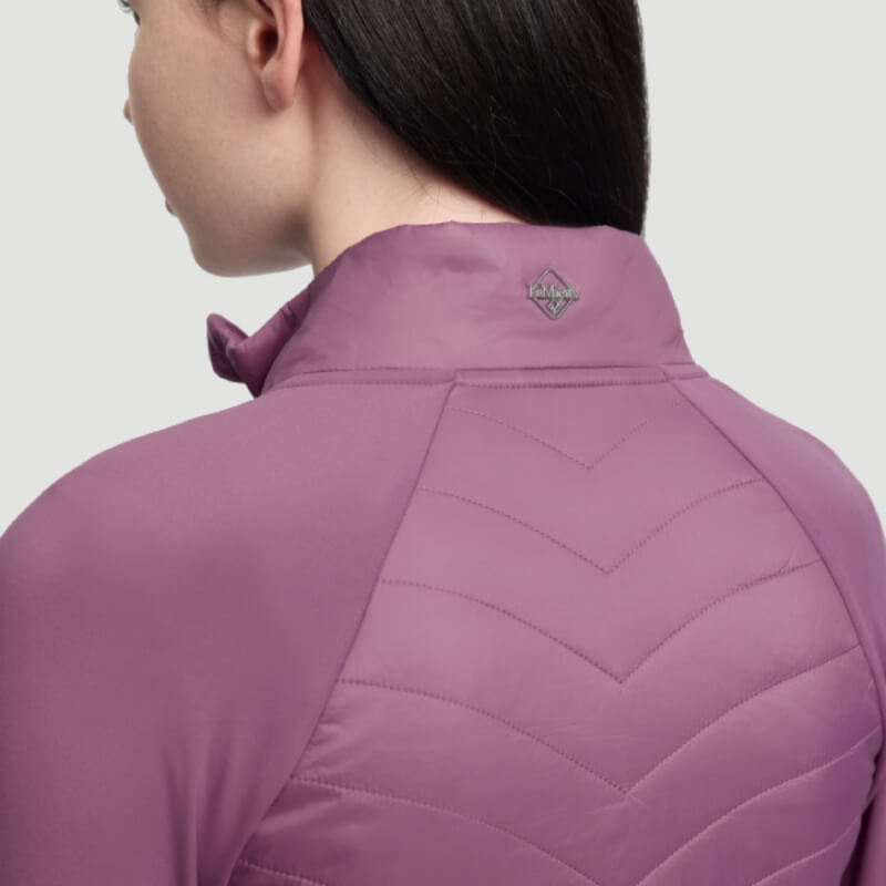 Woman in a LeMieux Young Rider Josephine Jacket Mallow, seen from behind with straight dark hair.