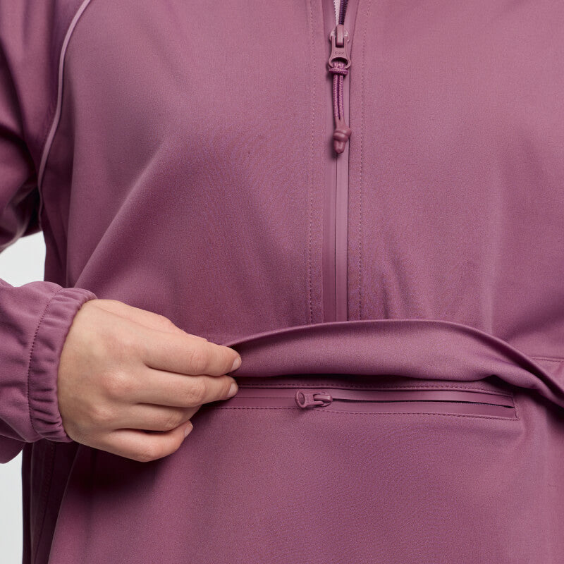 A young rider lifts the LeMieux Paige Quarter Zip jacket hem to reveal a hidden zipper pocket.
