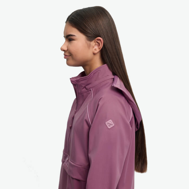 Girl in LeMieux Young Rider Paige Quarter Zip Jacket Mallow, facing left on white background.