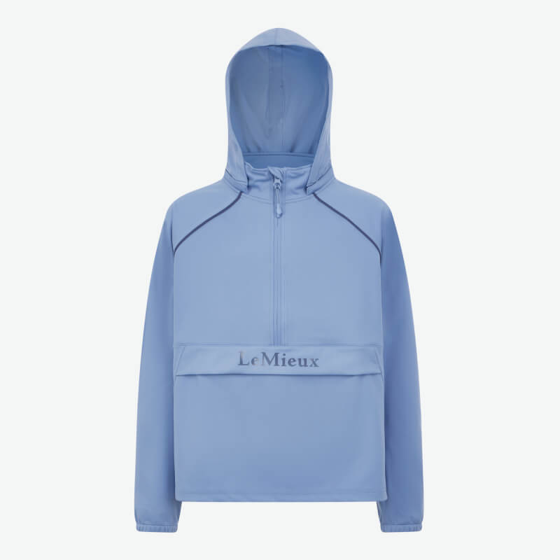 Woman in LeMieux Young Rider Paige Quarter Zip Waterproof Jacket, Powder Blue, smiling.