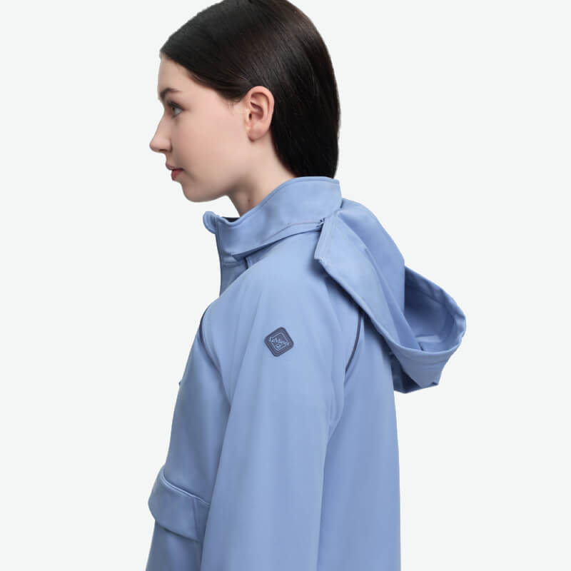 Woman in LeMieux Young Rider Paige Quarter Zip Waterproof Jacket in Powder Blue, side view.
