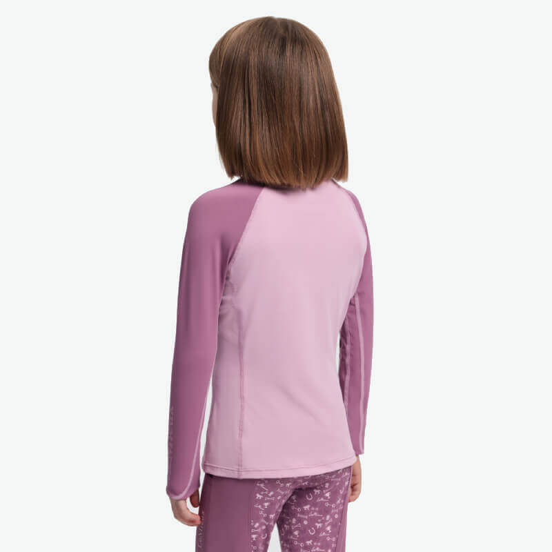 Young girl with brown hair in a LeMieux Mini Baselayer Fondant, shown from the back.