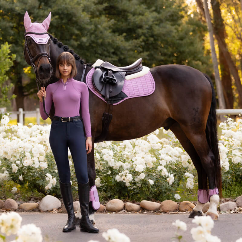 Rider stands by a dark horse with LeMieux Merino+ Suede Close Contact Square in Fondant shade.