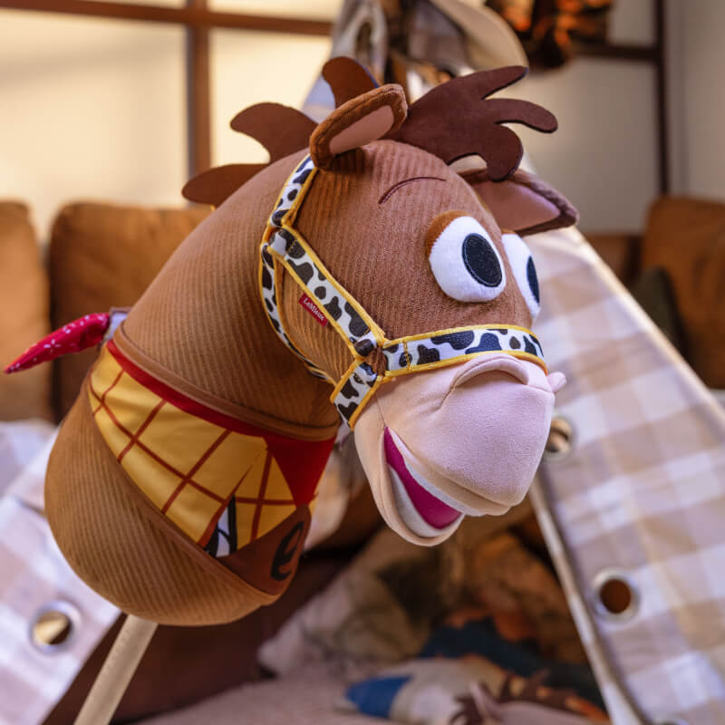 LeMieux Disney Hobby Horse Bullseye plush toy with big eyes and red bandana, indoor setting.