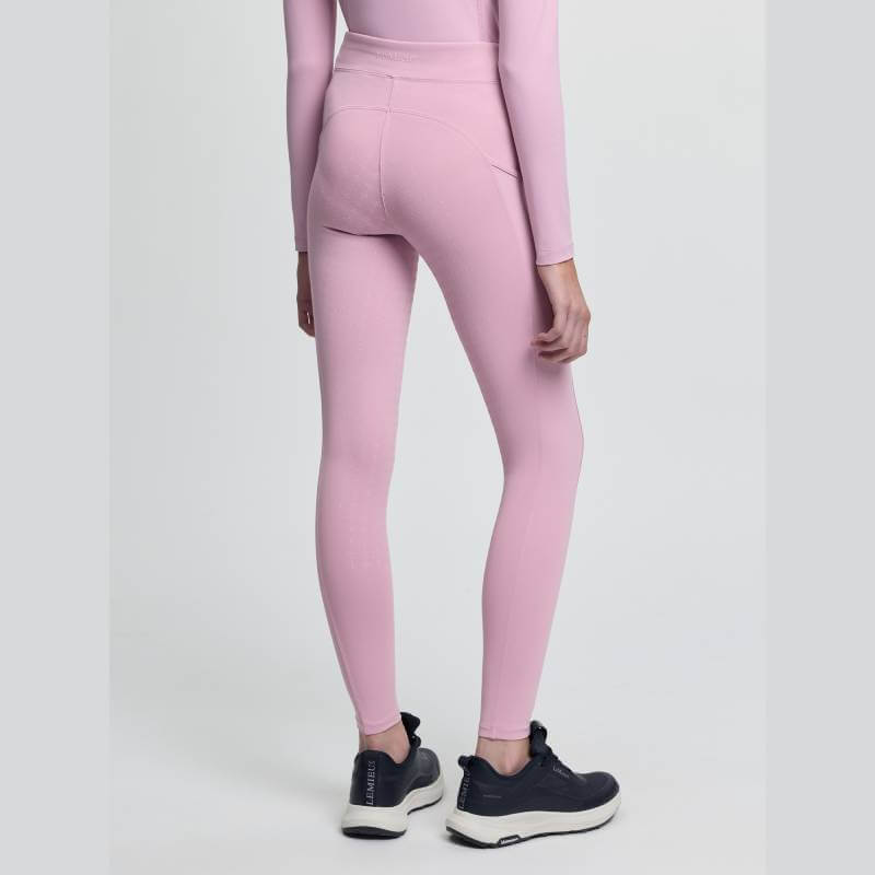 Young rider in LeMieux Orla Pull On Breech Fondant and top, black sneakers, light background.