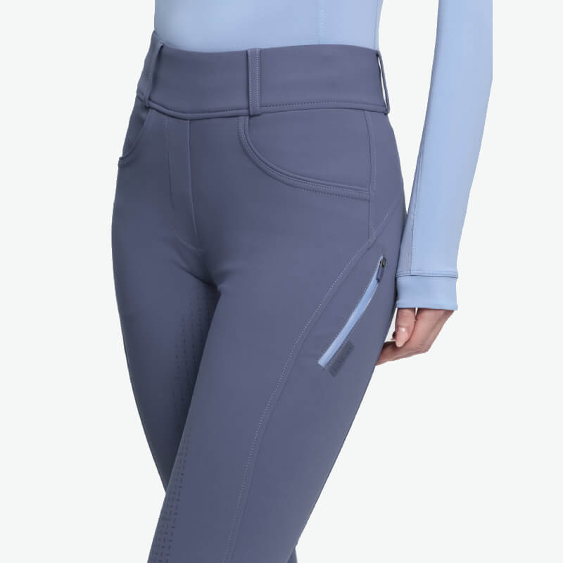 Person in LeMieux Amy Bregging Shadow breeches with zipper pocket and matching top.