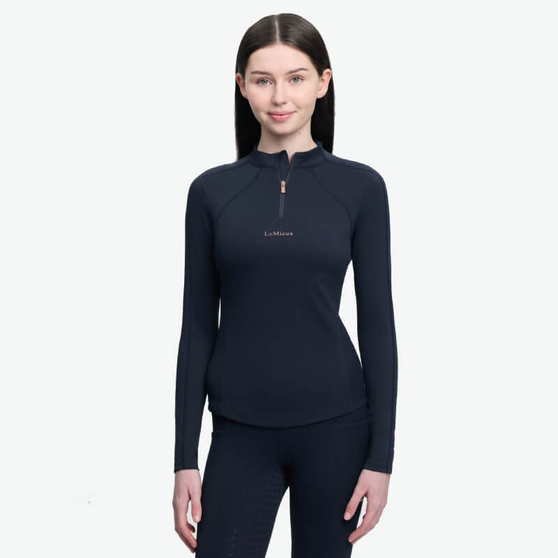 Young rider in LeMieux Young Rider Sparkle Baselayer Navy, standing and smiling.