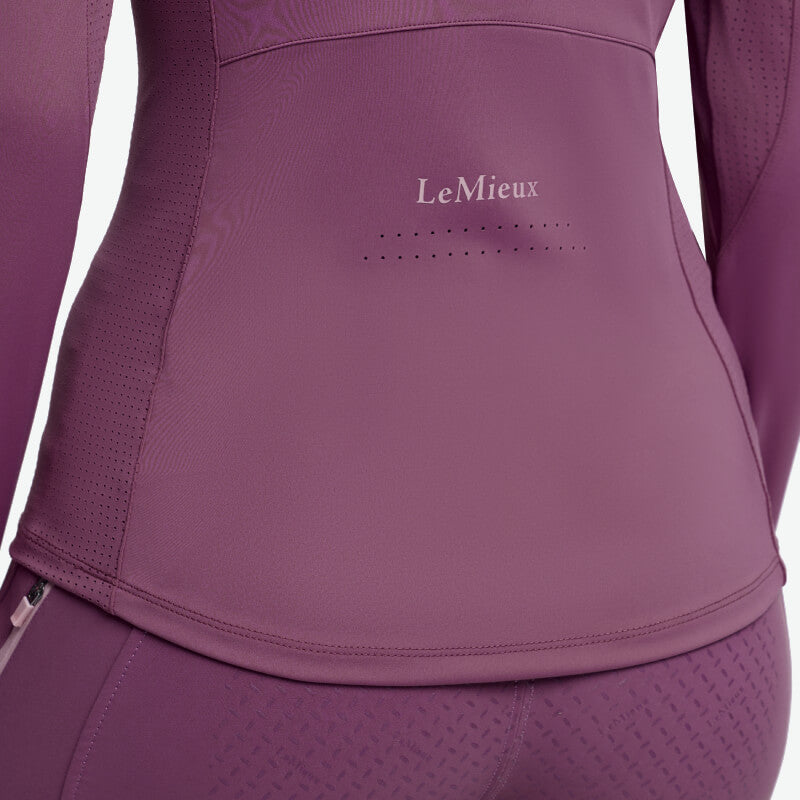 Close-up of a person in a LeMieux Young Rider Airflow Baselayer Mallow and matching leggings.