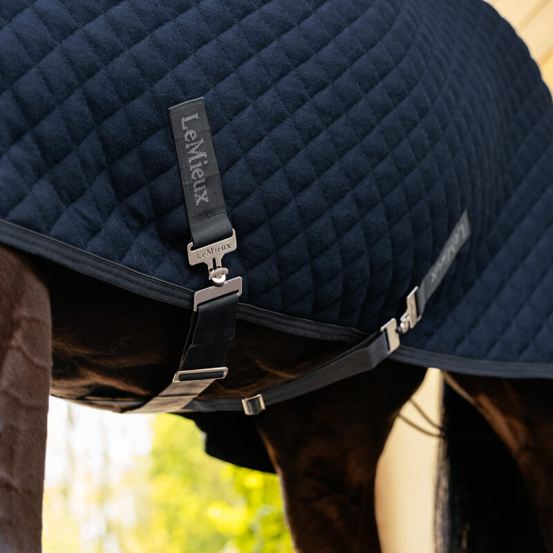 Close-up of LeMieux Arika Clima-Tek Rug Navy, a moisture-wicking horse rug with metal fasteners.