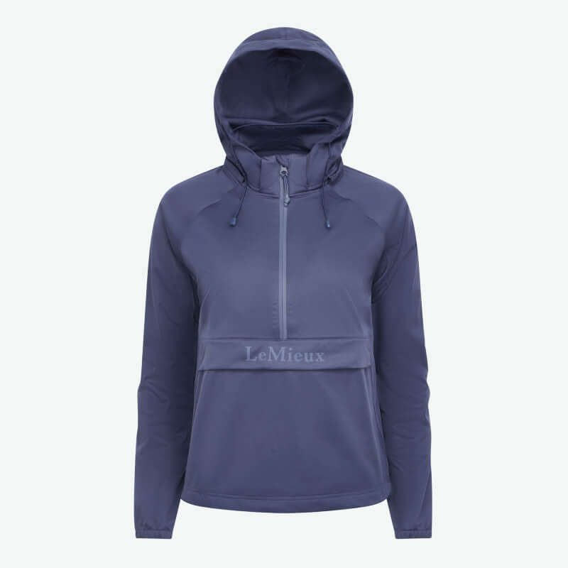 Woman wears the LeMieux Perri Half Zip Waterproof Hoodie Shadow, smiling on a white background.