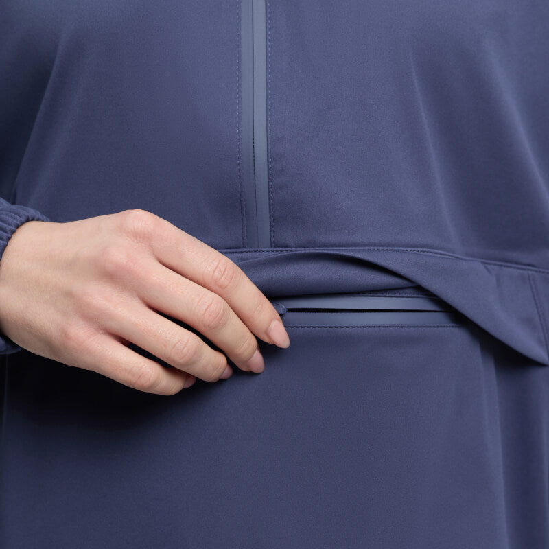 Hand opening a pocket on a LeMieux Perri Half Zip Waterproof Hoodie in Shadow.