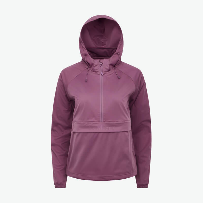 Smiling person in a LeMieux Perri Half Zip Waterproof Hoodie Mallow stands against white background.