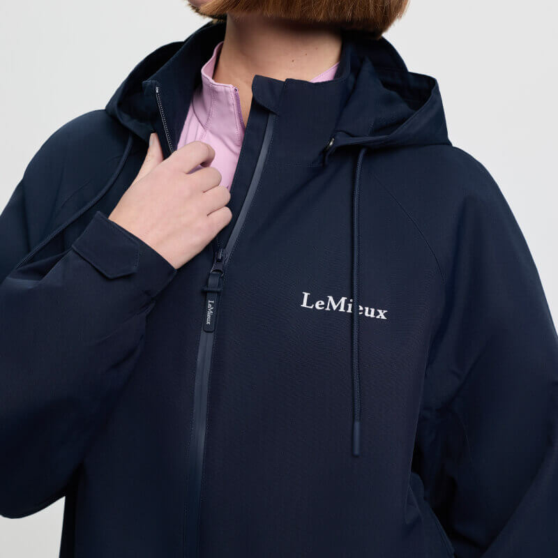 Wearing LeMieux Indra Waterproof Jacket Navy, hand near zipper.
