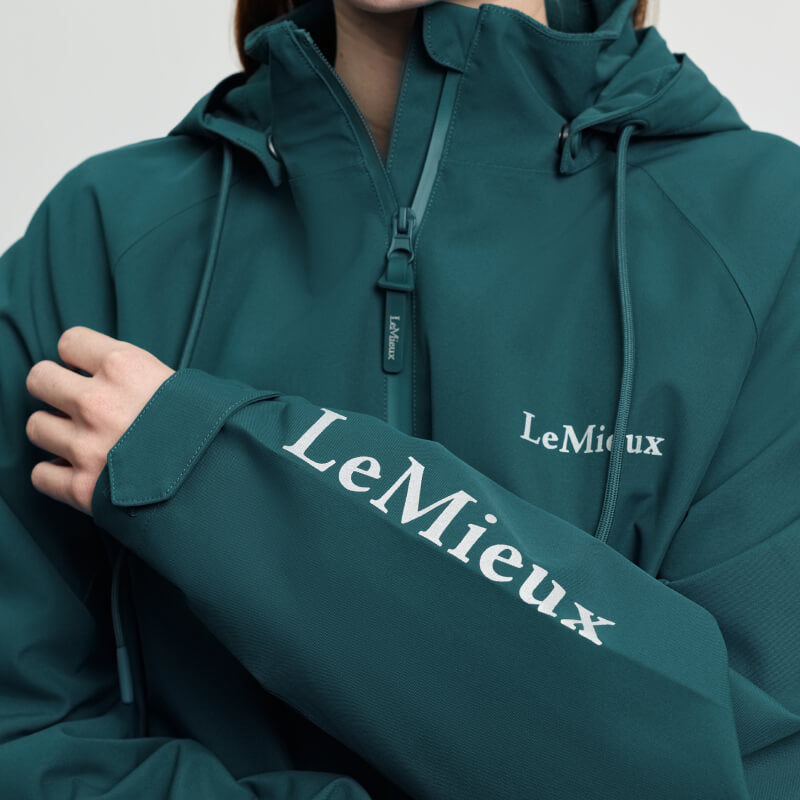 Person wears a LeMieux Indra Waterproof Jacket Jungle with logos on chest and sleeve.