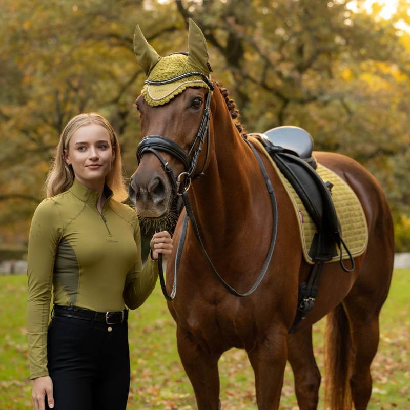 Woman with brown horse in matching green LeMieux Classique Baselayer Gooseberry, enjoying park.