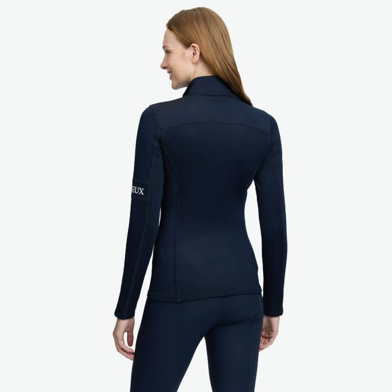 Woman in LeMieux Matila Midlayer Navy by LeMieux, smiling against white background.